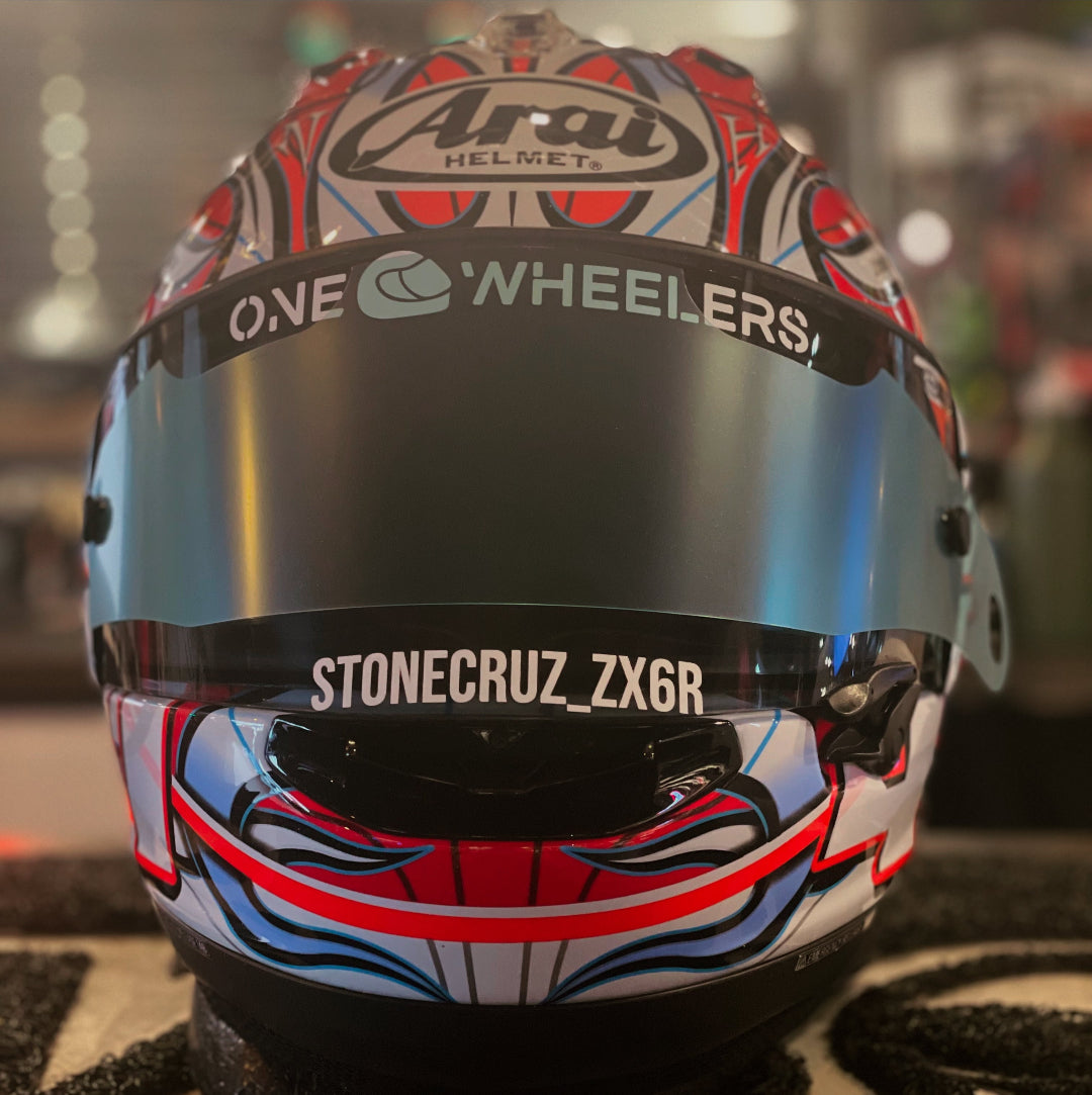 Colorful motorcycle helmet with onewheelers sticker branding on a blurred background