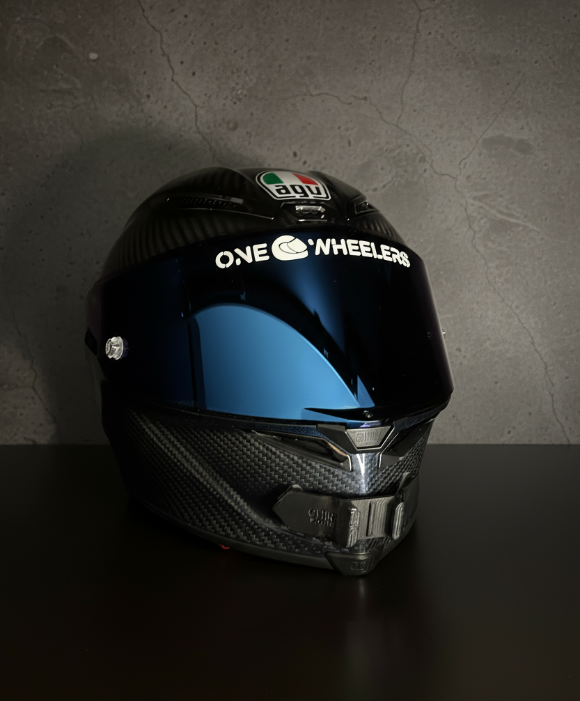 Black motorcycle helmet with 'One Wheelers' branding on a dark background